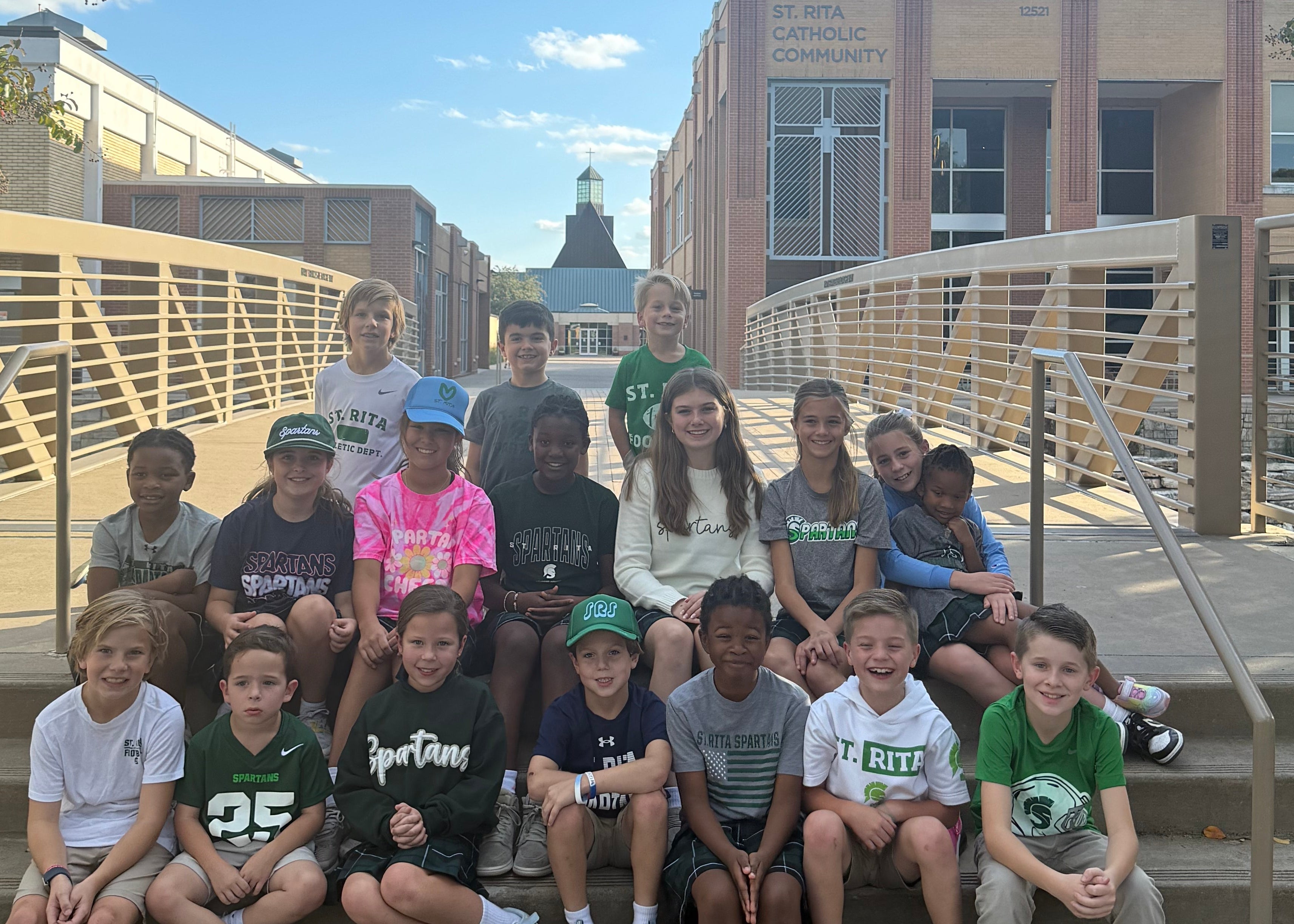 Group of people posing on a set of outdoor steps with a building in the background
